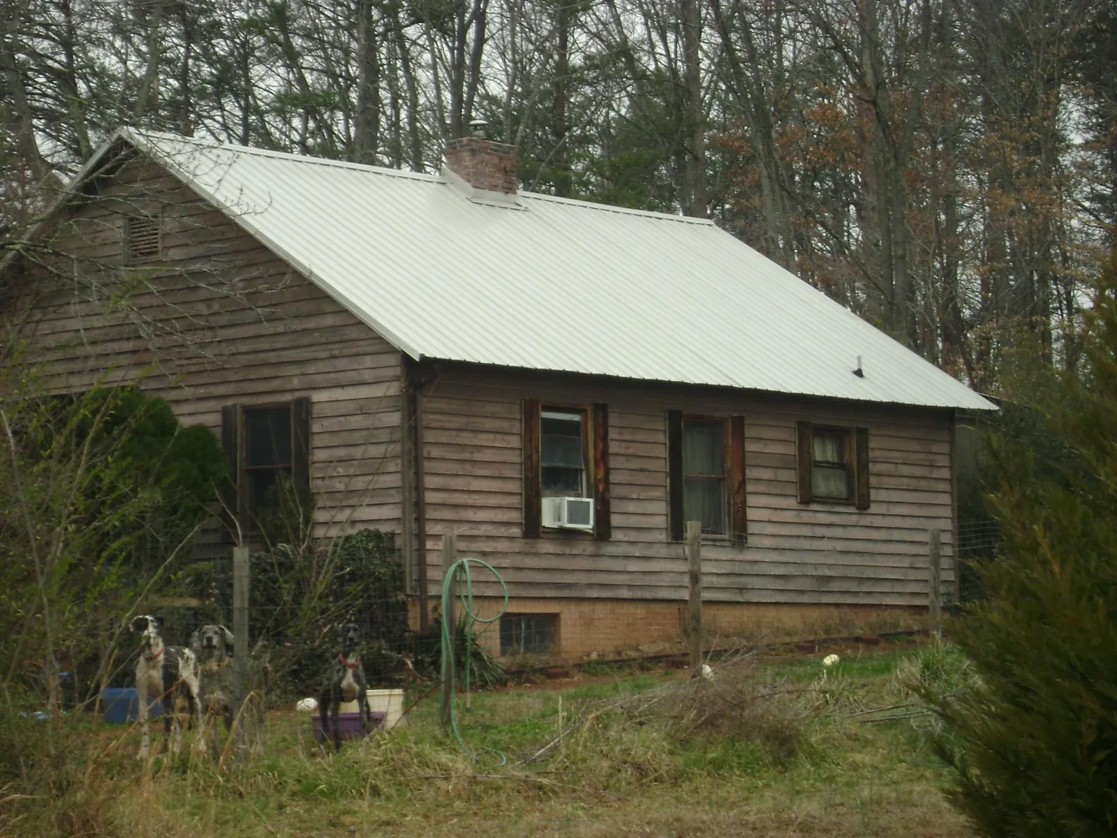 White metal roof on an old wood sided farmhouse, from a Metal Roof Installation job in Chanute